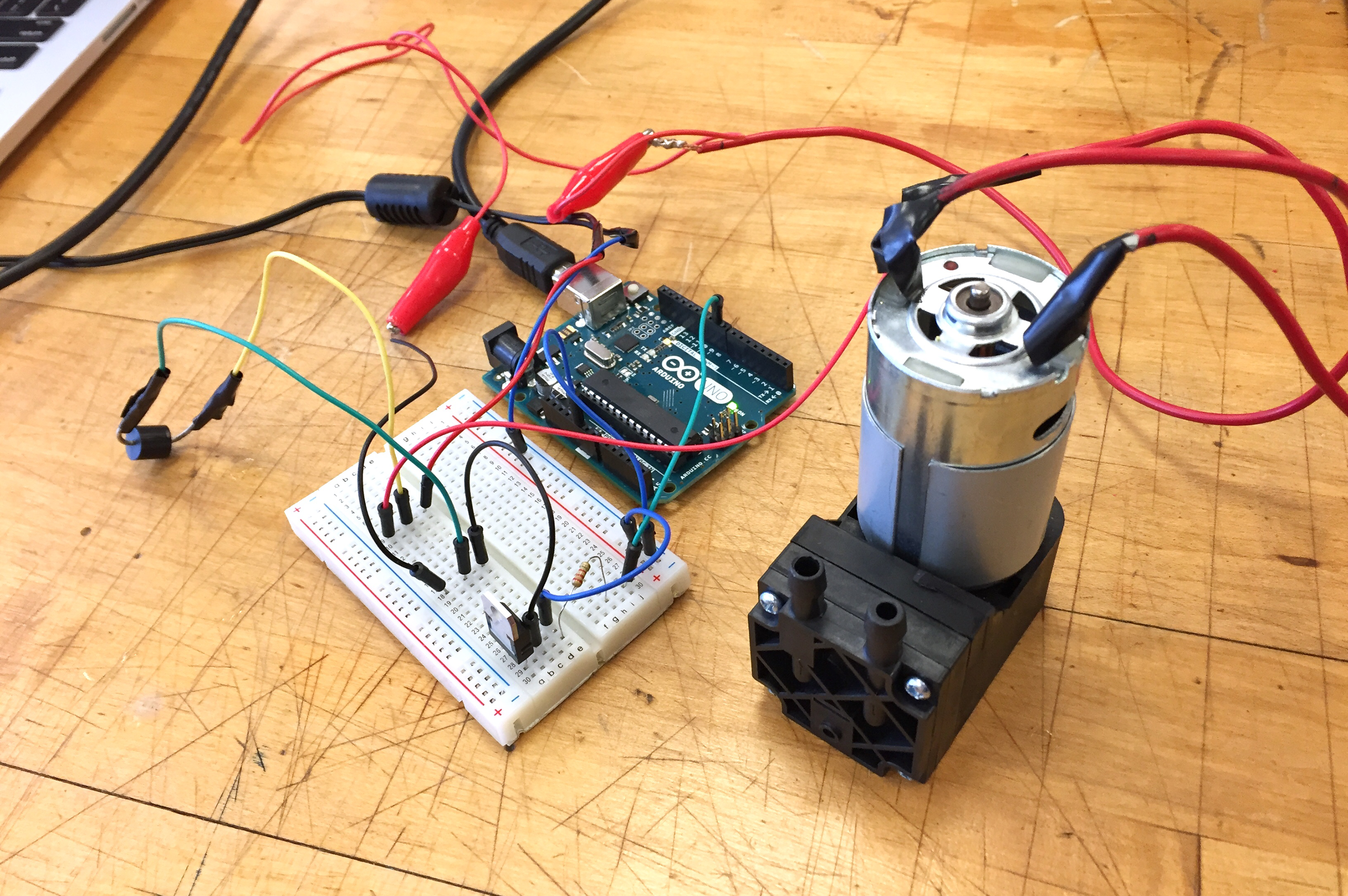 A messy electronic circuit on a table, with an Arduino.